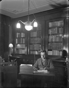 853621 Afbeelding van de arts E.J. Haanschoten in de spreekkamer van zijn praktijk (A.R. Falckstraat 7) te Utrecht.